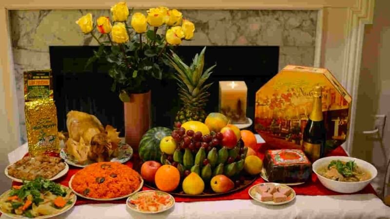 Bàn thờ gia tiên trang nghiêm với mâm ngũ quả và hoa tươi trong lễ cúng giao thừa