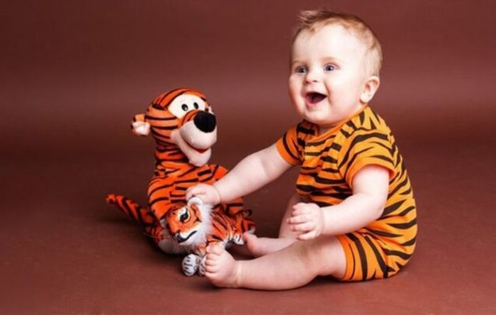 Em bé sinh năm 2022 nằm ngủ bên chú hổ, biểu tượng của tuổi Dần mạnh mẽ