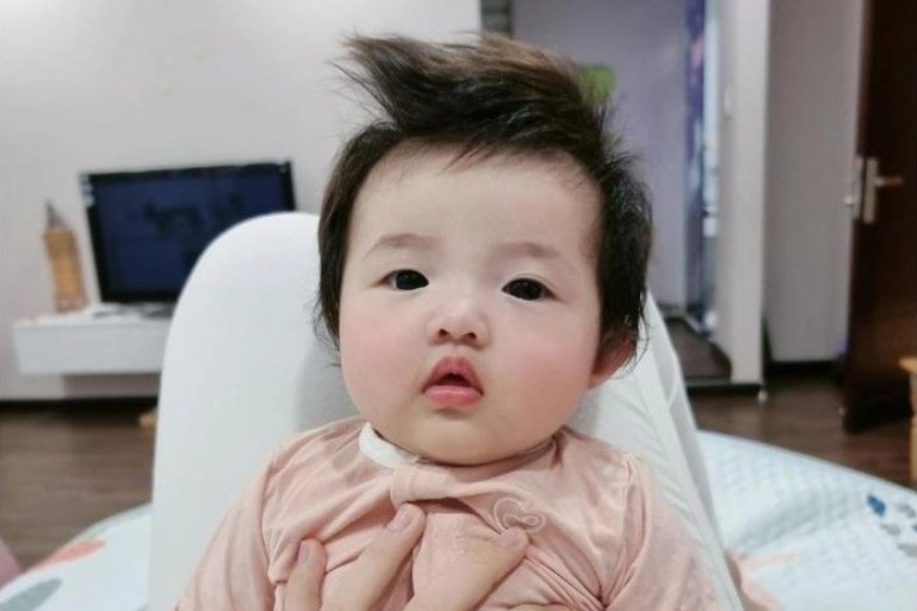 Cắt Tóc Cho Trẻ Sơ Sinh: Hướng Dẫn Chi Tiết 2026 Bé gái xinh xắn với kiểu tóc bồng bềnh