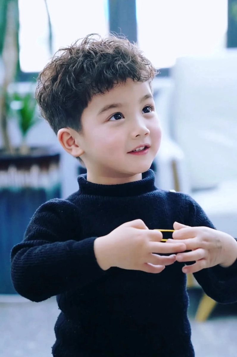 Bé trai với mái tóc xoăn mì tôm đáng yêu